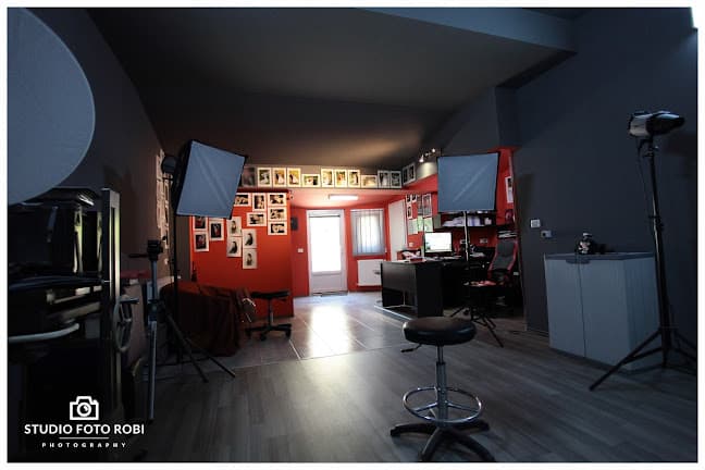 Interiorul studioului foto, cu perete de fotografii de nuntă și lumini profesionale